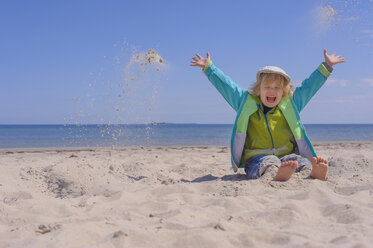 Deutschland, Mecklenburg Vorpommern, Junge spielt mit Sand an der Ostseeküste - MJF000202