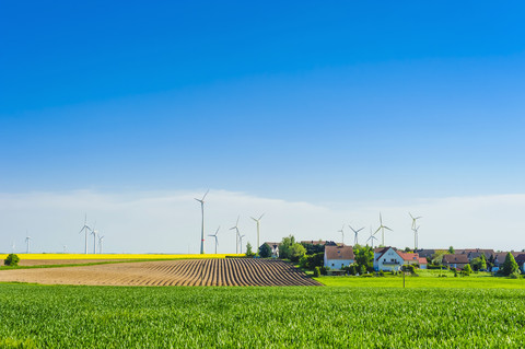 Deutschland, Sachsen, Windkraftanlagen im Rapsfeld, lizenzfreies Stockfoto