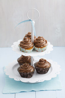 Mit Schokoladenbuttercreme überzogene Cupcakes auf Tortenständer, Nahaufnahme - ECF000180