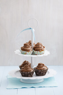 Mit Schokoladenbuttercreme überzogene Cupcakes auf Tortenständer, Nahaufnahme - ECF000179