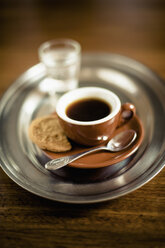 Espresso schwarzer Kaffee mit Keks und Glas Wasser auf dem Tablett - MJF000194