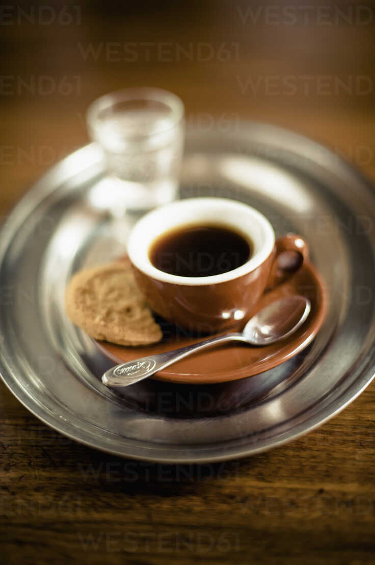 Espresso black coffee with cookie and glass of water on tray stock