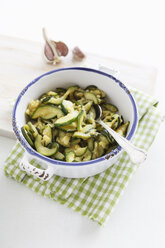 Bowl of fried zucchini on chopping board, close up - EVGF000123