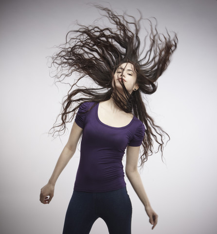 Porträt einer jungen Frau, die ihr Haar wirft, lizenzfreies Stockfoto