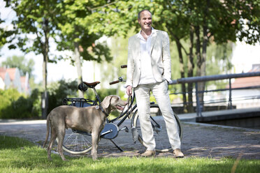 Deutschland, Bayern, Älterer Mann mit Weimaraner Hund, lächelnd - MAEF006825