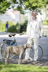 Deutschland, Bayern, Porträt eines reifen Mannes mit Weimaraner Hund, lächelnd - MAEF006831