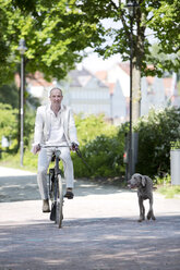 Deutschland, Bayern, Porträt eines reifen Mannes auf dem Fahrrad mit Weimaraner-Hund, lächelnd - MAEF006832