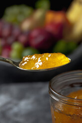Spoon and glass bowl of apricot jam, close up - CSF019418