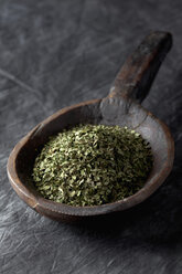 Wooden spoon with coriander on textile, close up - CSF019483