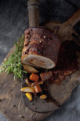 Rolled roast pork and braised vegetables on wooden board, close up - CSF019429