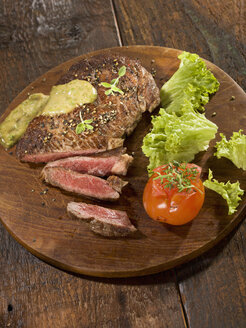 Gegrilltes Rib-Eye-Steak mit Kräutersauce auf Holzplatte - CHF000029