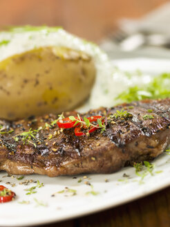 Rump steak with baked potato on square plate, close up - CHF000033