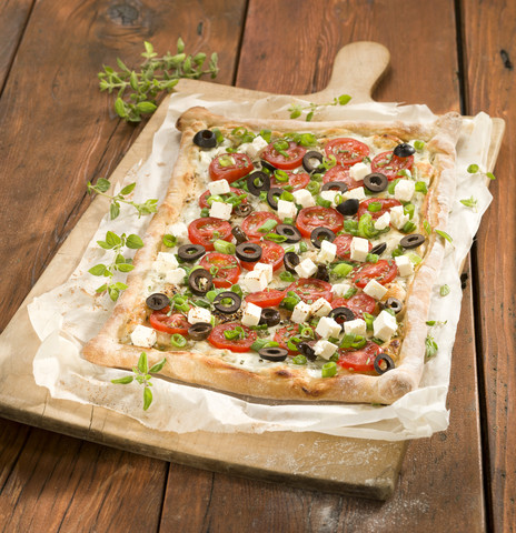 Tarte mit Tomatenscheibe und Feta-Käse auf Pizzabrett, lizenzfreies Stockfoto