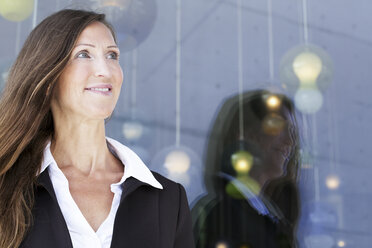 Germany, Berlin, Businesswoman looking away, smiling - FKIF000009