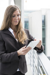 Germany, Berlin, Businesswoman using digital tablet, smiling - FKIF000018