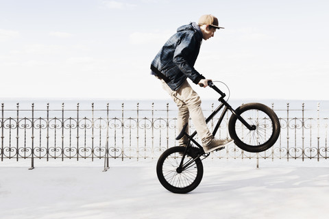 Deutschland, Schleswig Holstein, Jugendlicher springt mit BMX-Rad, lizenzfreies Stockfoto