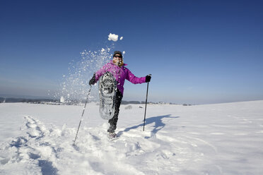 Eine Wanderin tritt den Schnee in Richtung Kamera - LH000177