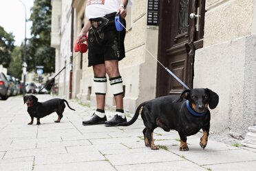 Deutschland, Bayern, München, Älterer Mann beim Spaziergang mit Hunden - ED000030
