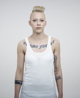 Portrait of young woman with tattoos against white background - RH000224