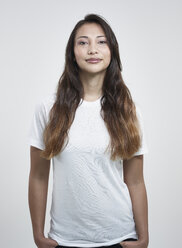 Portrait of young woman against white background, smiling - RH000196