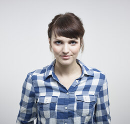 Portrait of young woman against white background, smiling - RH000193