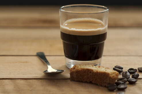 Glas Espresso mit gerösteter Kaffeebohne und Brot auf Holztisch, Nahaufnahme - OD000029