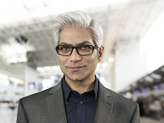 Portrait of businessman at airport, smiling - STKF000298