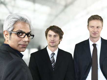 Businessmen at airport, smiling - STKF000294