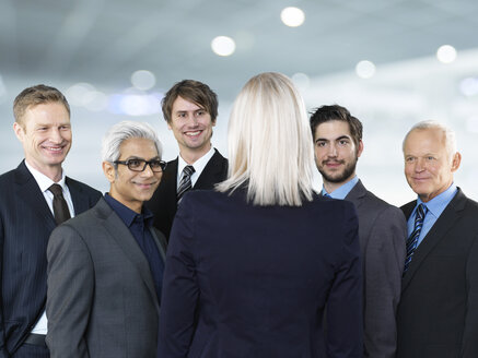 Businessmen and businesswoman talking, smiling - STKF000292