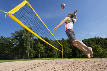 Deutschland, Älterer Mann spielt Beachvolleyball - STSF000030