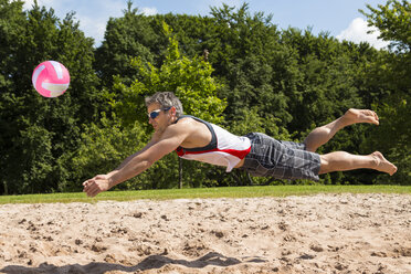 Deutschland, Älterer Mann spielt Beachvolleyball - STSF000032