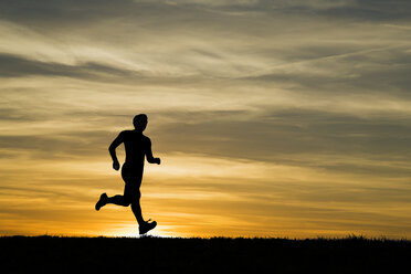 Deutschland, Älterer Mann joggt bei Sonnenuntergang - STSF000034