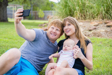 Familie fotografiert sich selbst, lächelnd - ABAF000890