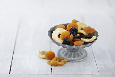 Bowl of dried fruits on wooden table, close up - KSW001083