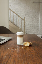 Croissant auf dem Tisch mit Getränk und Laptop - FMKYF000345