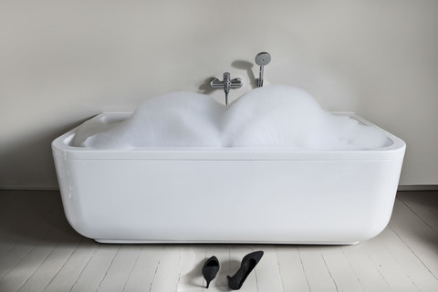 Badewanne mit hochhackigen Schuhen im Badezimmer, lizenzfreies Stockfoto