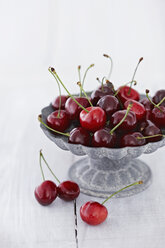 Bowl of cherries on wooden table, close up - KSW001127