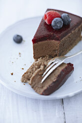 Schokoladenkäsekuchen mit Himbeeren und Heidelbeeren auf einem Teller, Nahaufnahme - KSW001131