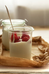 Glas Joghurt mit Himbeeren auf Holztisch, Nahaufnahme - OD000065