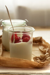 Glass of yoghurt with raspberries on wooden table,close up - OD000065