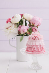 Rosa Mini-Torte mit Blumenbouquet auf dem Tisch, Nahaufnahme - ECF000210