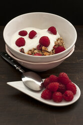 Bowl of muesli with raspberries on wooden table, close up - OD000077