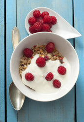 Bowl of muesli with raspberries on wooden table, close up - OD000074