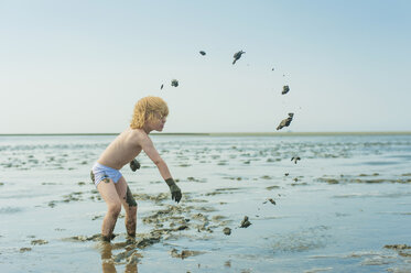 Deutschland, Schleswig Holstein, Junge spielt im Schlamm am Strand - MJF000223