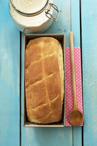 Weißbrot im Backblech mit Holzlöffel und Serviette, lizenzfreies Stockfoto