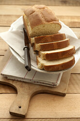 Sliced milk bread in bowl with knife, close up - OD000101