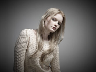 Portrait of young woman standing against grey background - RH000267