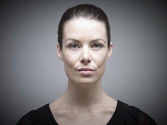 Portrait of young woman against grey background, close up - RH000248