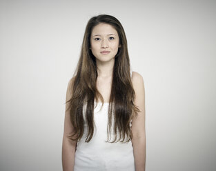 Porträt einer jungen Frau vor weißem Hintergrund, lächelnd - RH000244