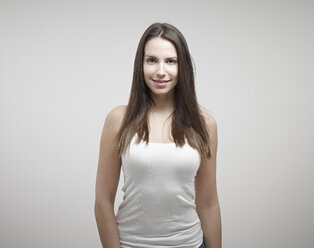 Porträt einer jungen Frau vor weißem Hintergrund, lächelnd - RH000242